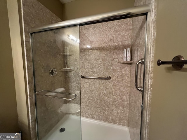 bathroom with a shower with door