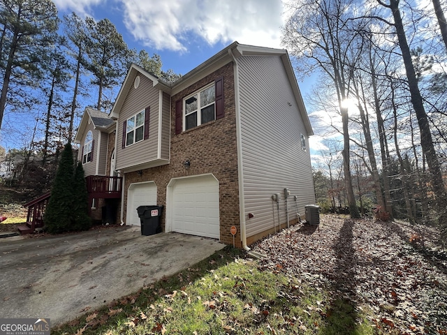 view of home's exterior with central AC unit and a garage