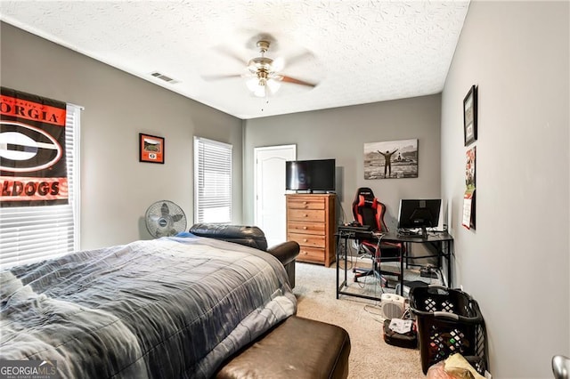 bedroom featuring carpet flooring, a textured ceiling, and ceiling fan