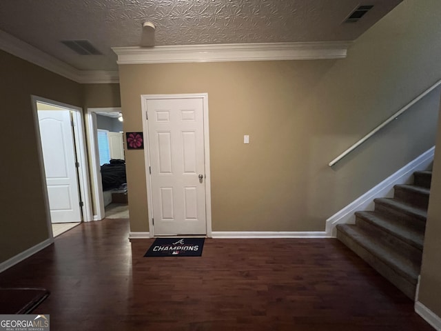 foyer featuring a textured ceiling, dark hardwood / wood-style floors, and crown molding