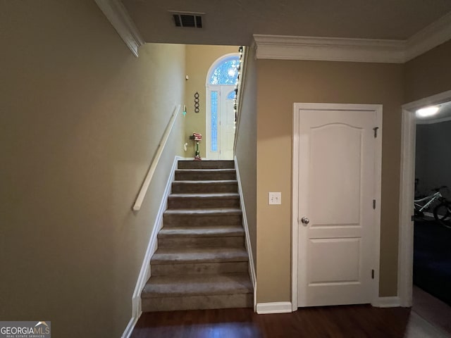 stairway featuring wood-type flooring and ornamental molding