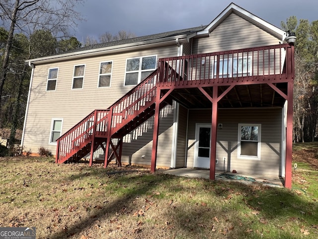 rear view of property with a yard and a deck