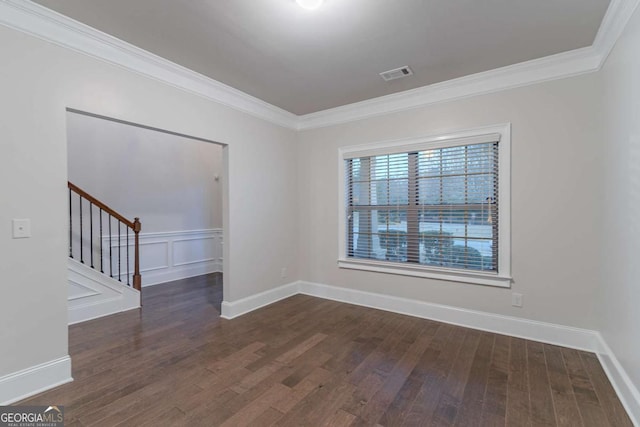 spare room featuring ornamental molding and dark wood-type flooring