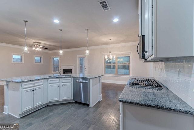 kitchen featuring sink, hanging light fixtures, stainless steel appliances, an island with sink, and white cabinets