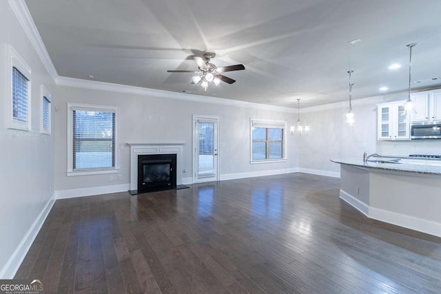 unfurnished living room with plenty of natural light, dark hardwood / wood-style floors, and ornamental molding