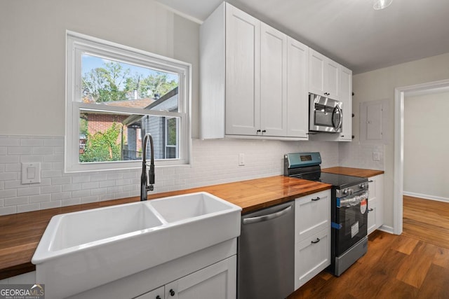 kitchen with butcher block countertops, sink, white cabinets, and appliances with stainless steel finishes