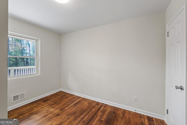 empty room with dark hardwood / wood-style flooring