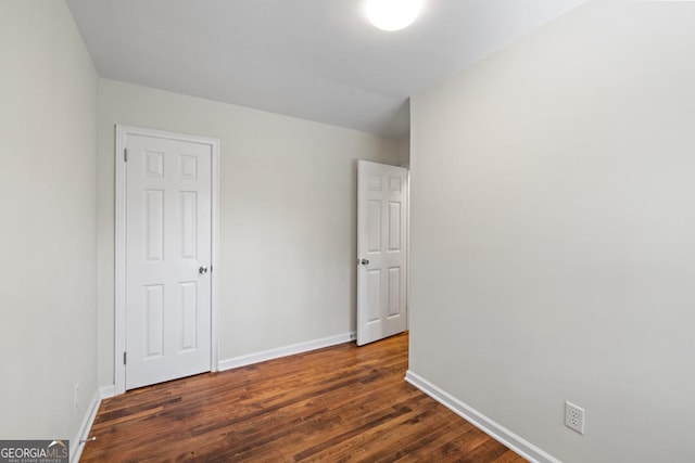 unfurnished bedroom with dark wood-type flooring