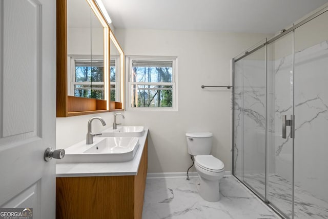 bathroom featuring a shower with door, vanity, and toilet