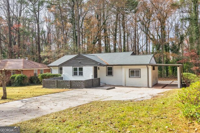 single story home featuring a front yard and a carport