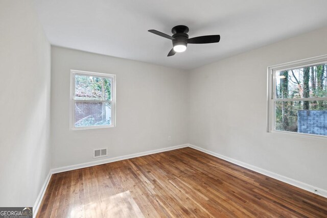 unfurnished room with ceiling fan, plenty of natural light, and wood-type flooring