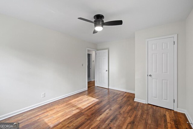 unfurnished bedroom featuring ceiling fan and dark hardwood / wood-style flooring