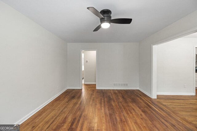 empty room featuring ceiling fan and dark hardwood / wood-style floors