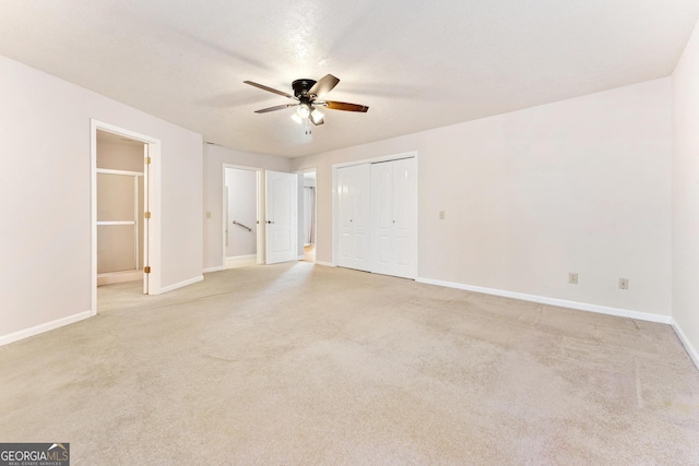 unfurnished bedroom featuring a closet, ceiling fan, and light colored carpet