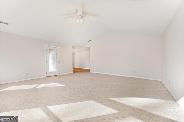 carpeted spare room with ceiling fan and vaulted ceiling