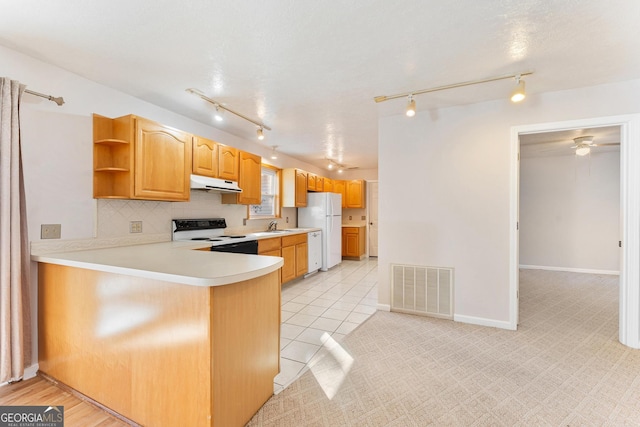 kitchen with sink, tasteful backsplash, kitchen peninsula, white appliances, and light tile patterned floors