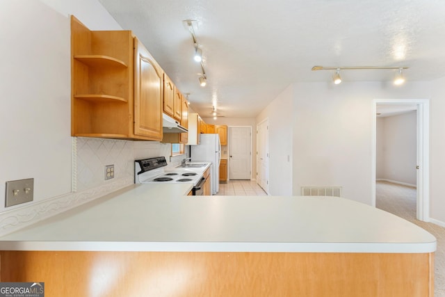 kitchen featuring kitchen peninsula, white appliances, rail lighting, and light tile patterned flooring