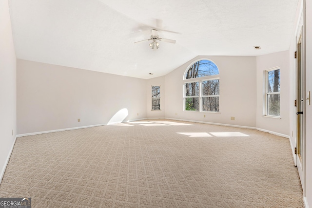 interior space featuring ceiling fan, light colored carpet, and vaulted ceiling