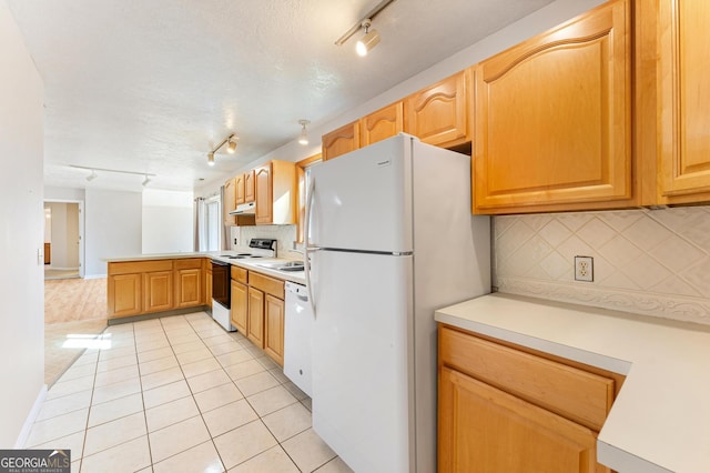 kitchen featuring tasteful backsplash, white appliances, light tile patterned floors, and track lighting