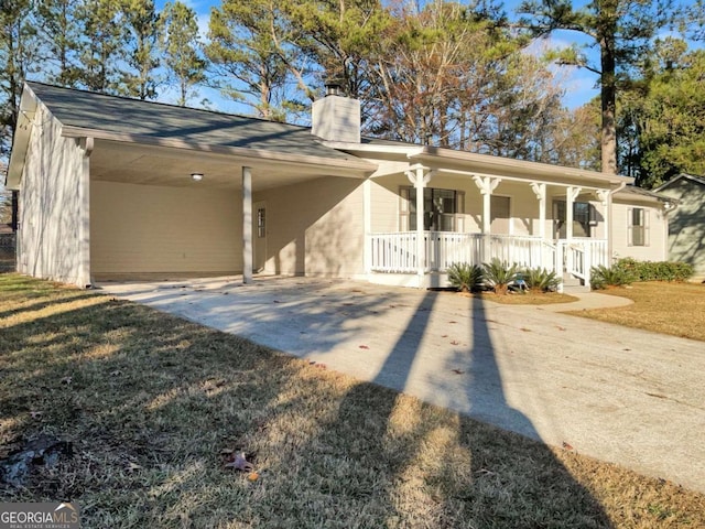 view of front of house featuring a front lawn, covered porch, and a carport