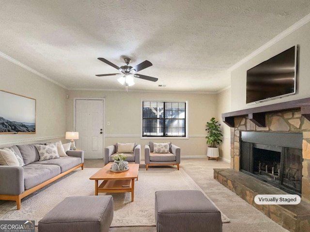 carpeted living room with a fireplace, a textured ceiling, ceiling fan, and ornamental molding