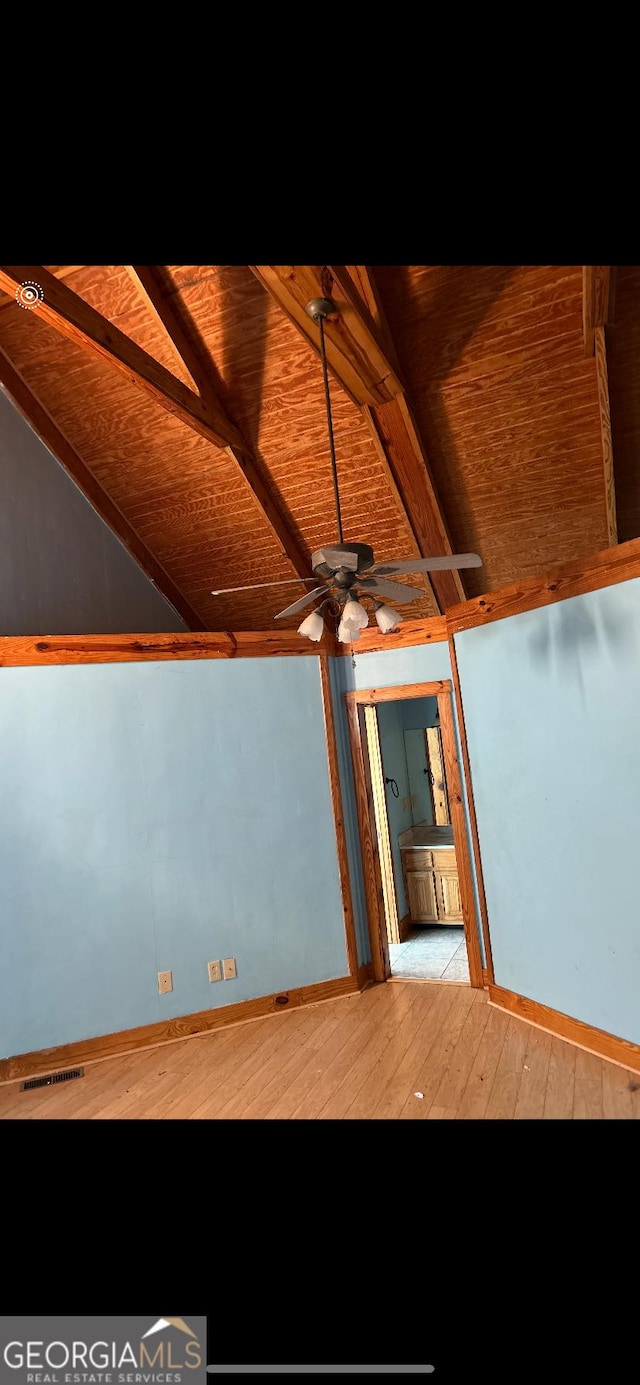 spare room with light wood-type flooring, lofted ceiling with beams, ceiling fan, and wooden ceiling