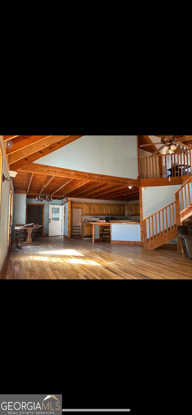 interior space with hardwood / wood-style flooring and vaulted ceiling with beams