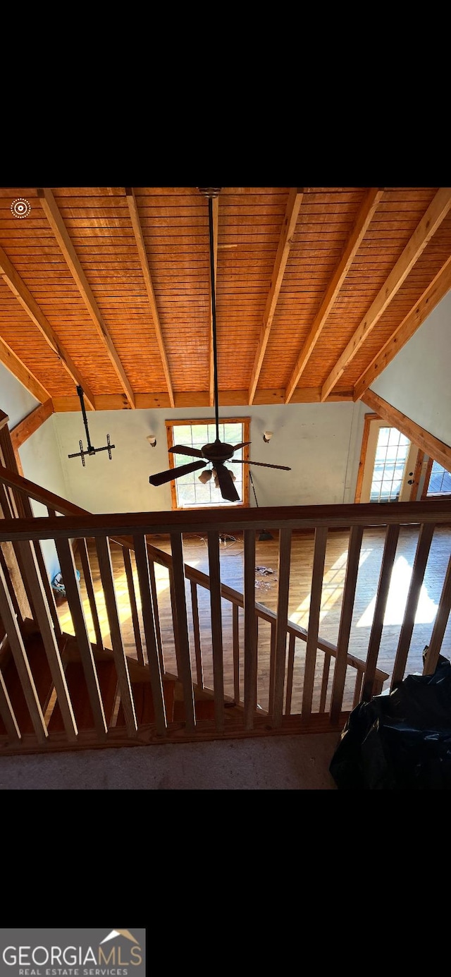 stairs with lofted ceiling with beams, ceiling fan, and wood ceiling