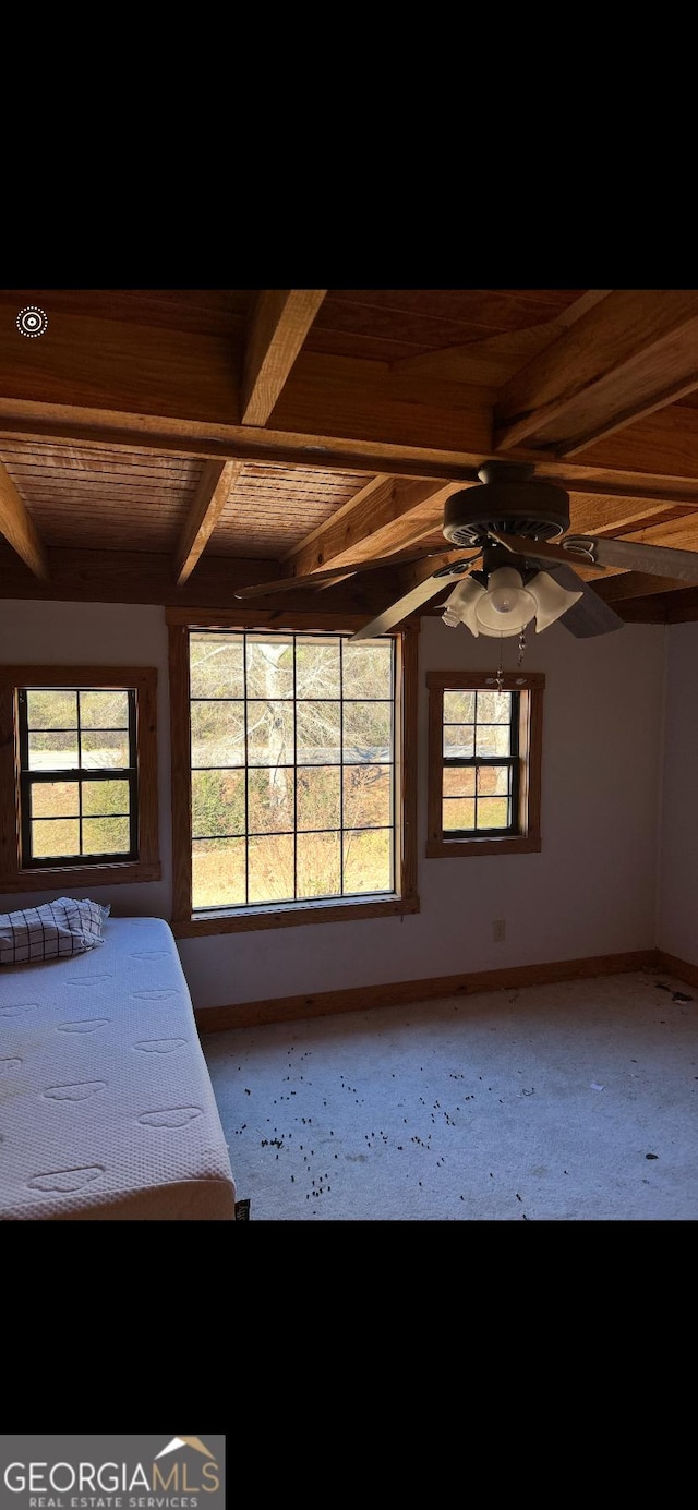 unfurnished bedroom featuring ceiling fan, beamed ceiling, and wood ceiling