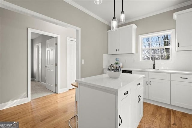 kitchen with white cabinets, a kitchen island, and sink