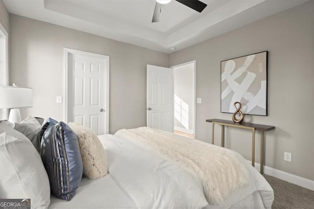 bedroom with carpet, ceiling fan, and a raised ceiling