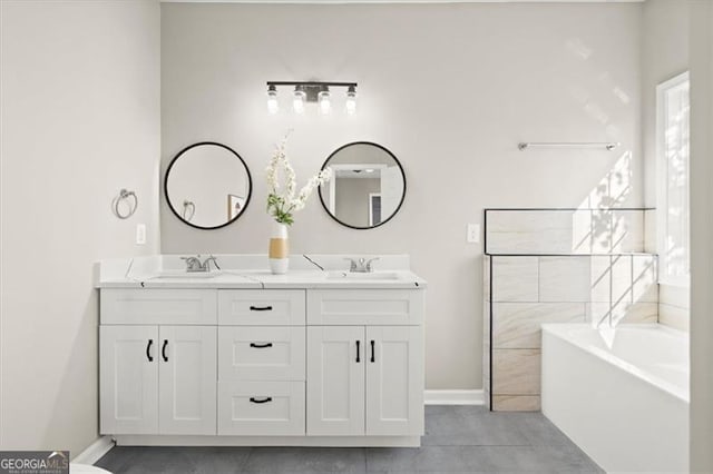 bathroom with tile patterned floors, a washtub, and vanity