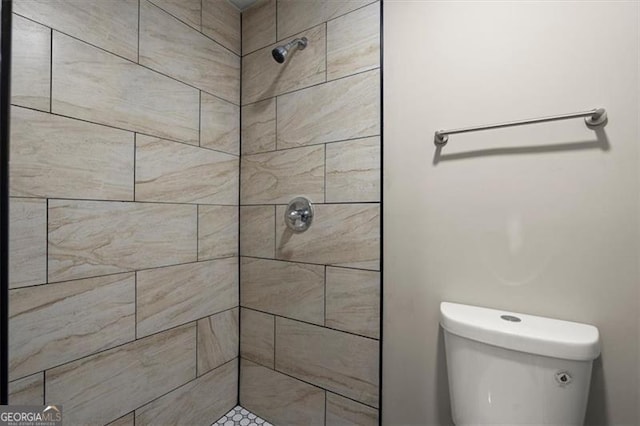 bathroom with toilet and tiled shower