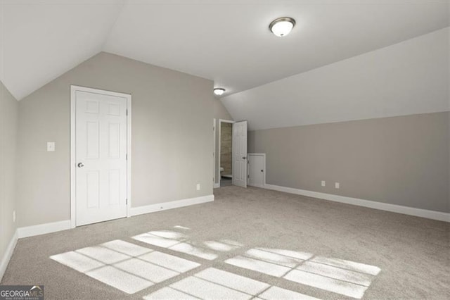 additional living space featuring carpet flooring and lofted ceiling