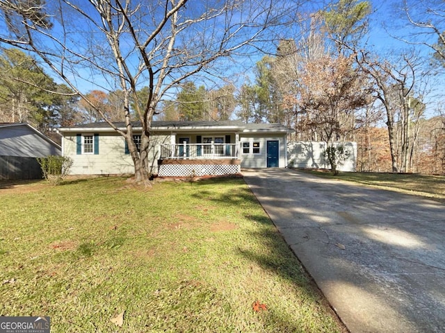 ranch-style house featuring covered porch and a front yard