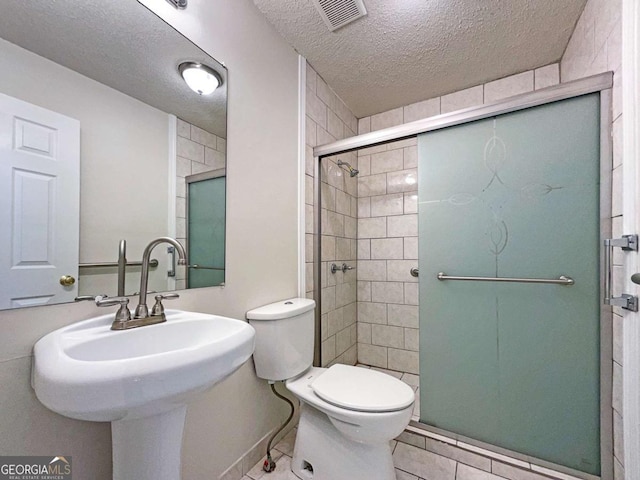 bathroom with sink, walk in shower, tile patterned flooring, a textured ceiling, and toilet