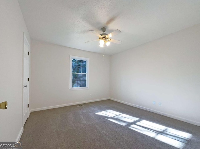 carpeted empty room featuring ceiling fan and a textured ceiling