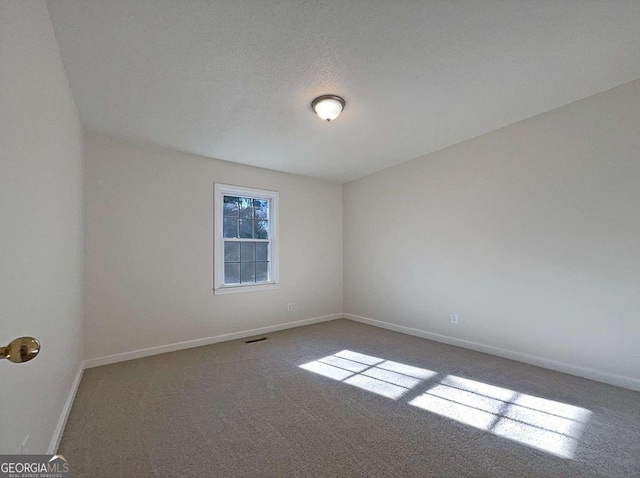 spare room with carpet flooring and a textured ceiling