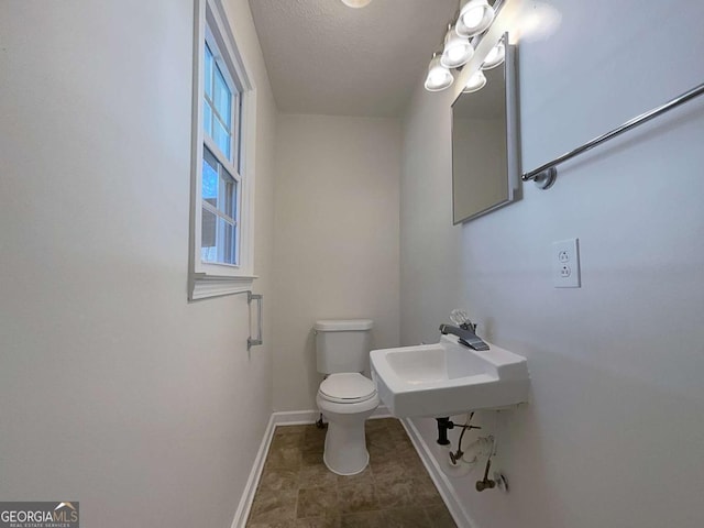 bathroom featuring a textured ceiling and toilet