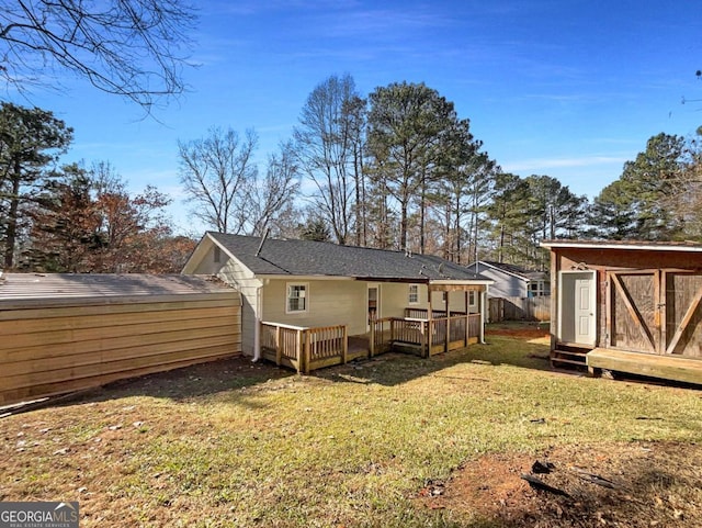 rear view of property with a lawn and a storage shed