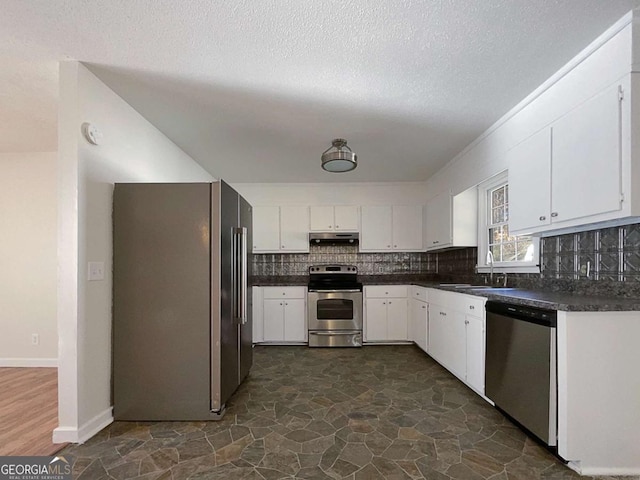 kitchen with sink, stainless steel appliances, a textured ceiling, decorative backsplash, and white cabinets