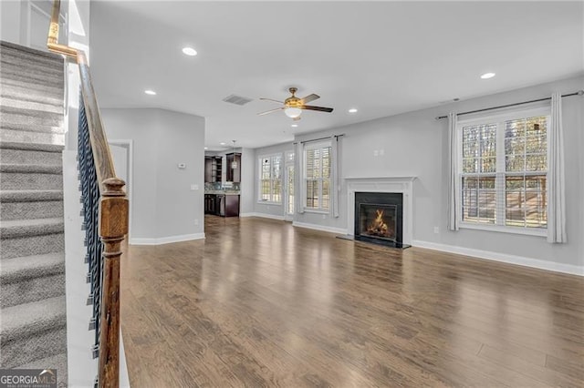 unfurnished living room with dark hardwood / wood-style floors and ceiling fan