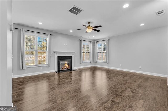 unfurnished living room with ceiling fan and dark wood-type flooring