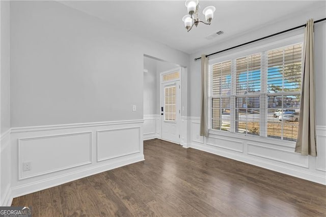 unfurnished room with dark hardwood / wood-style flooring and an inviting chandelier