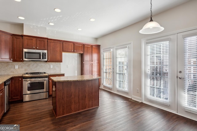 kitchen featuring dark wood-type flooring, a wealth of natural light, hanging light fixtures, and stainless steel appliances