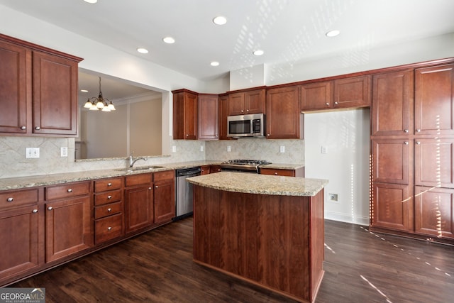 kitchen featuring backsplash, stainless steel appliances, sink, decorative light fixtures, and dark hardwood / wood-style floors