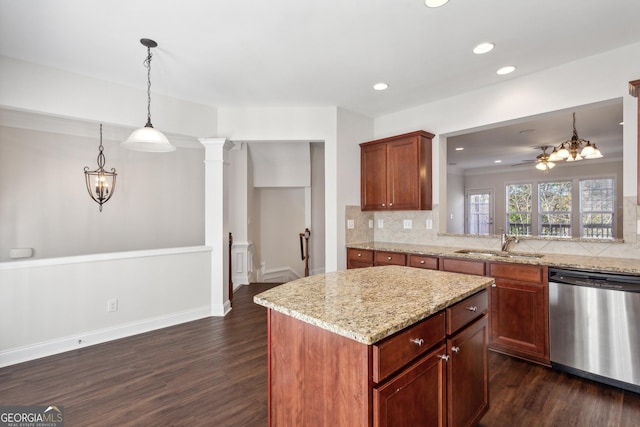 kitchen with dark hardwood / wood-style floors, sink, stainless steel dishwasher, and decorative light fixtures