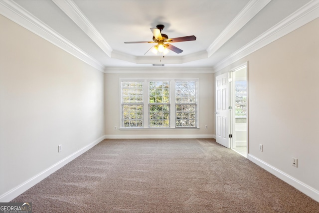 empty room featuring carpet flooring, ceiling fan, a tray ceiling, and ornamental molding