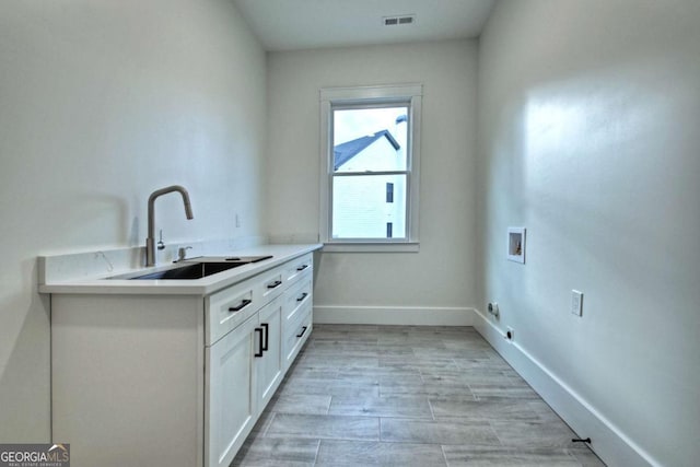 clothes washing area featuring visible vents, hookup for an electric dryer, cabinet space, a sink, and washer hookup