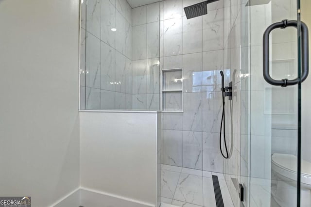 bathroom featuring tiled shower and toilet